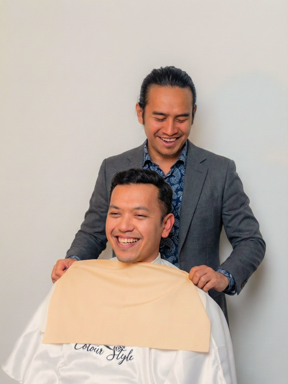 Colour draping session — client with vivid fabric swatches held to reveal her season